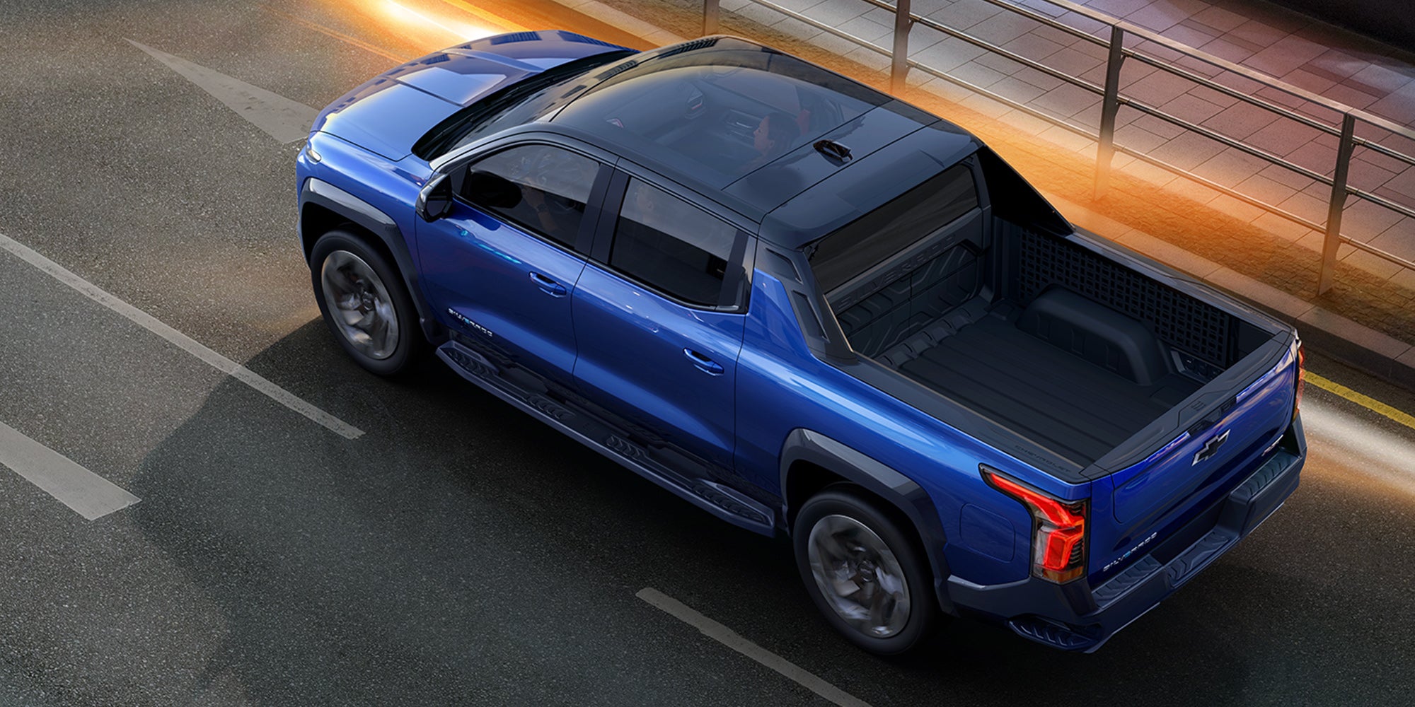 A blue Silverado EV Running on the road top and left view 