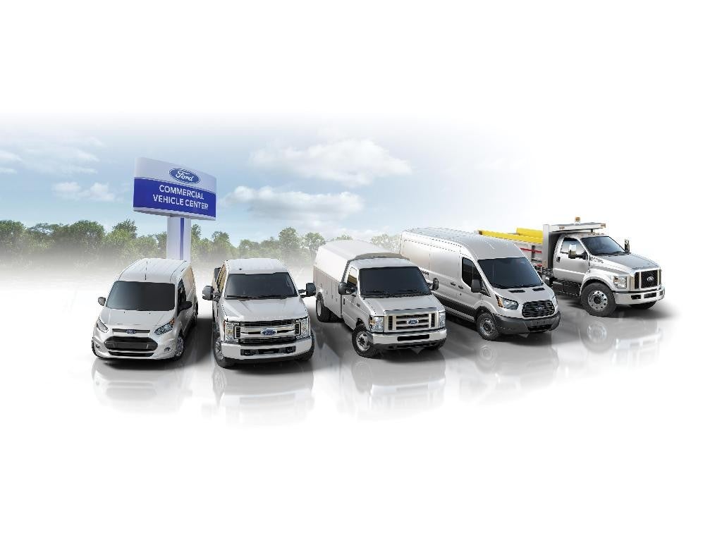 Ford commercial vehicles lined up near Ford Hording