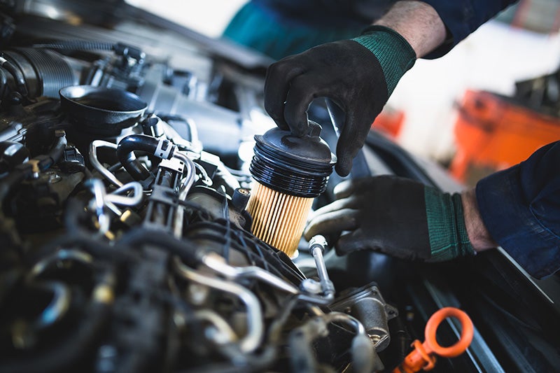 A mechanic installing a Oil Filter